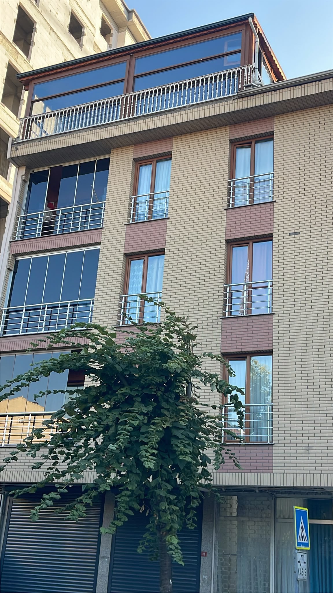 Çatı katı kış bahçesi giyotin camla kapatılmış apartman cephesi, sokaktan görünüm