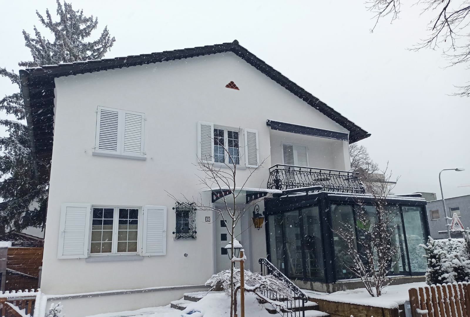 Karlı evin cephesinde kış bahçesi