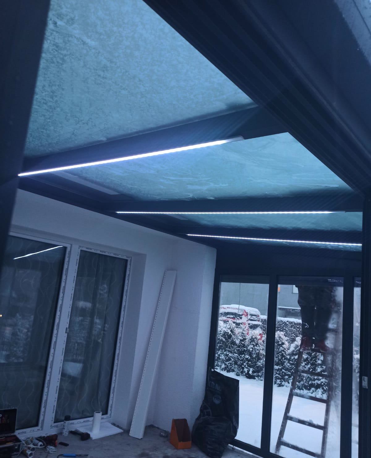 Kış bahçesinin içinden cam çatı ve karlı bahçe